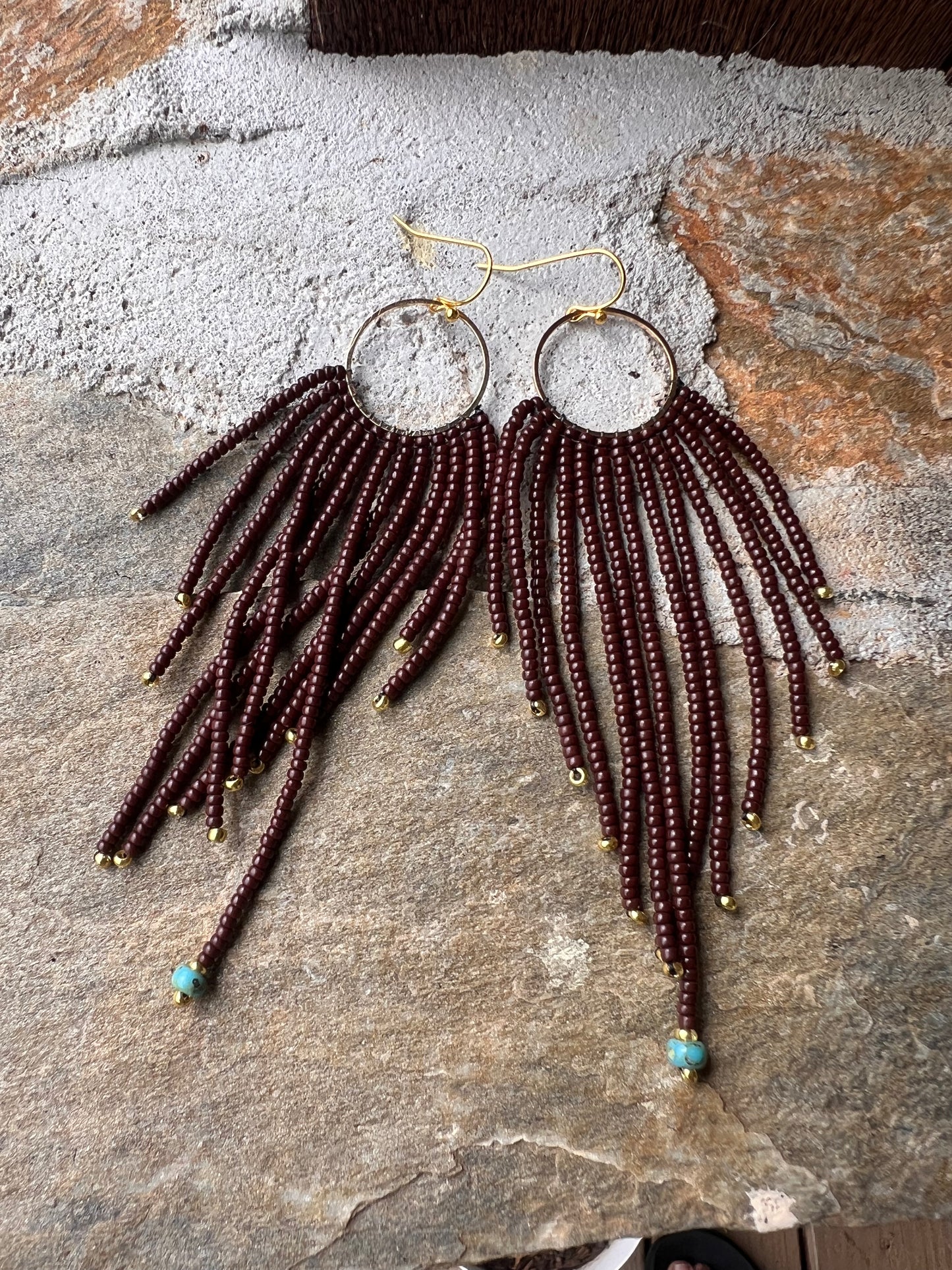 Brown beaded earrings with brass pendant