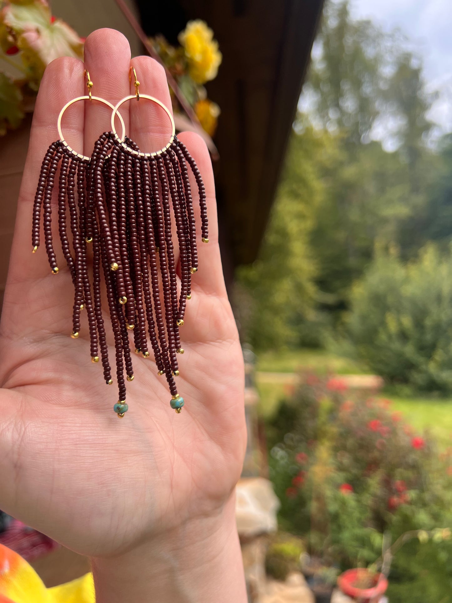 Brown beaded earrings with brass pendant