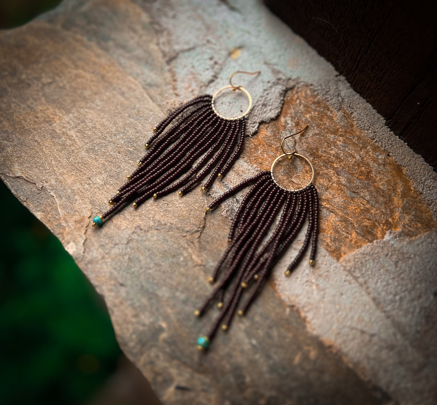 Brown beaded earrings with brass pendant